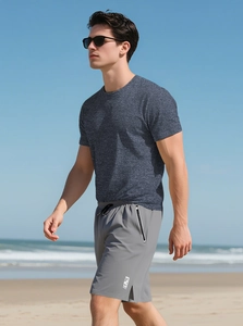 Detail of grey men's slim fit sports t-shirt and functional shorts at the beach