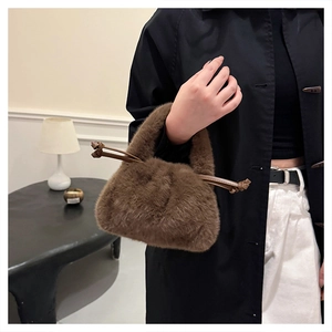 Detailed view of a brown faux fur handbag with leather drawstring handles for autumn winter