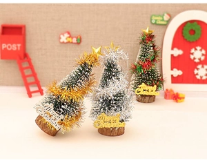 Detailed view of mini Christmas trees with colorful tinsel and Merry Christmas wooden bases