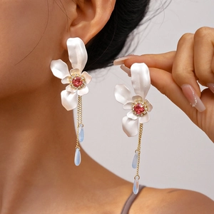 Detail shot of elegant floral earrings with pink gemstones and light blue teardrop beads