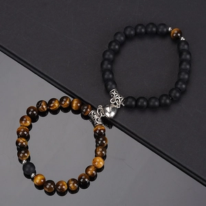 Detail view of heart-shaped magnetic clasp on tiger eye and matte black stone bracelets