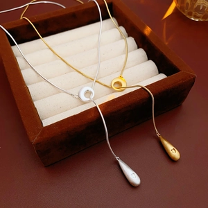 Detailed view of gold and silver Y-shaped drop necklaces with sleek brushed finish