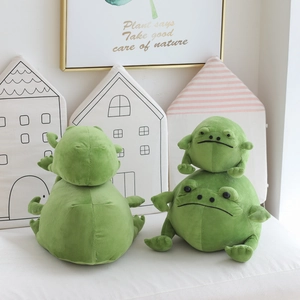 Close-up of green plush frog dolls in two sizes featuring a cozy home setting decor