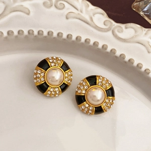 Detail of vintage flower stud earrings with white pearl and black enamel accents