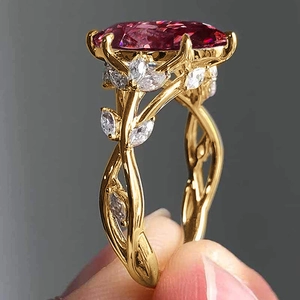 Macro view of gold vine ring featuring a large oval pink gemstone and marquise diamonds