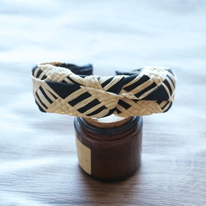 Detail view of woven raffia headband with black fabric diamond pattern texture