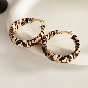 Retro leopard print hoop earrings with gold metal base on a white ceramic plate