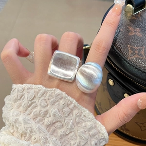 Close-up of matte silver vintage square and oval rings with brushed metal texture