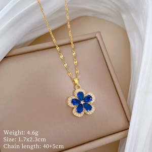 Detail view of a gold moon necklace with blue flower pendant and cz stones on silk