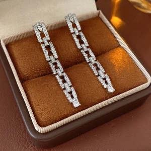 Vue détaillée des boucles d'oreilles chaînes en argent et zircons dans leur boîte