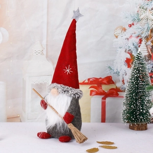 Standing Christmas gnome with red pointed hat and broom against festive background