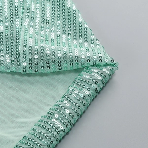 Detail of mint green sequin fabric with pleated texture on elegant evening dress