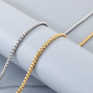 Gros plan sur la texture tissée détaillée des chaînes dragon en acier plaqué or 18 carats