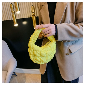 Detail of the lemon yellow quilted cloud bag with padded nylon texture and handle