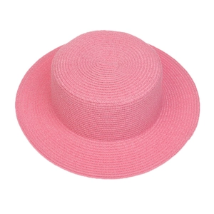 Detailed close-up of pink woven straw texture and flat wide brim on a summer sun hat