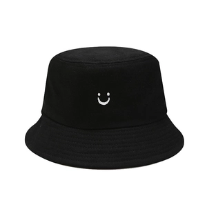 Unisex black cotton bucket hat featuring white smiley face embroidery for outdoor sun protection