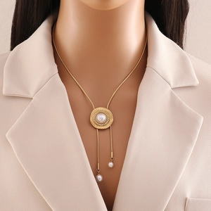 Stainless steel long tassel necklace with pearl flower pendant on a beige blazer