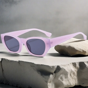 Detail view of purple rectangular sunglasses placed on rustic stones for a retro aesthetic