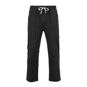 Dettaglio dei pantaloni in lino a righe verticali bianche e nere con coulisse bianca