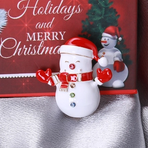 Vue rapprochée d'une broche bonhomme de neige sertie de strass sur un coffret cadeau