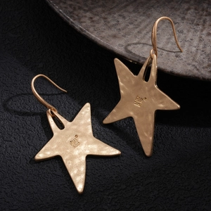 Detail shot of vintage gold star earrings showing hammered texture and S925 engraving