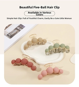 Detail of matte hair claws in Morandi colors arranged on a white decorative tray