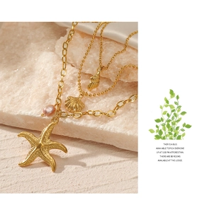Detailed close-up of triple-layered ocean necklace with starfish, shell and pink pearl