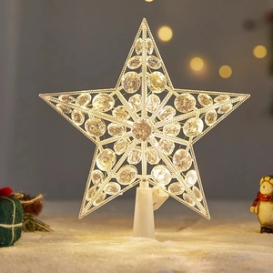 Close-up of LED lit star tree topper with crystal beads on a snowy display surface