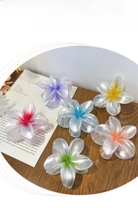 Close-up of six colorful plumeria flower hair claws with a matte translucent finish