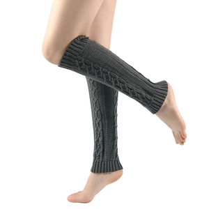 Detailed close-up of dark grey cable knit leg warmers with ribbed cuffs on model legs