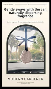 Detailed view of white camellia plaster diffuser hanging with a black ribbon in a car