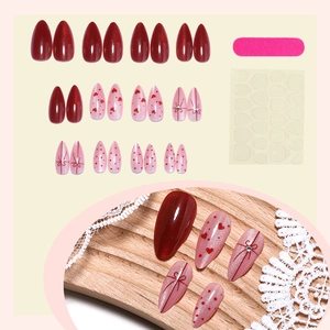 Cat-eye almond press-on nails set with red hearts, bow accents, and tool kit