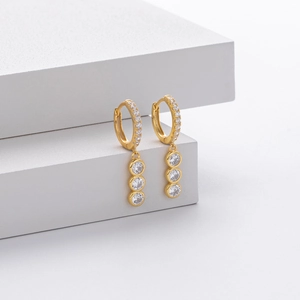 Close-up of gold-plated s925 sterling silver hoop earrings with sparkling stone dangles
