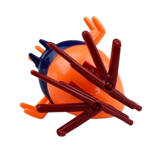 Detailed top view of the orange wind-up clockwork insect toy on a white background