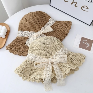 Detailed top view of foldable straw hats with elegant white lace bow ribbons