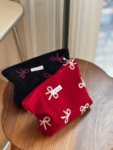 Detailed embroidery of chic bowknot on corduroy cosmetic bags in red and black