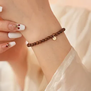 Minimalist agarwood beaded bracelet for women with elegant 18k gold circular pendant charm