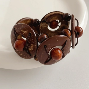 Detail of vintage elastic bracelet featuring geometric brown wood and coconut shell beads