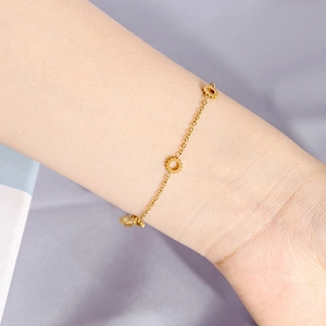 Detailed view of a gold dainty bracelet featuring three sunburst charms on a fine chain