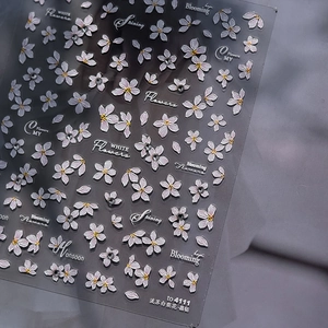 Detail of floral nail stickers with white pear blossoms, tiny crystals and lettering