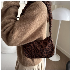 Dettaglio della borsa a spalla leopardata con tracolla plissettata su un outfit autunnale