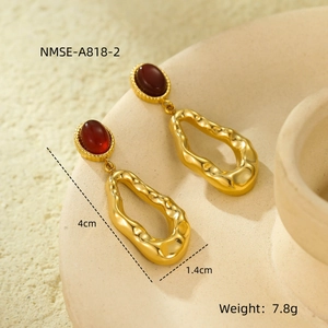 Detailed view of gold irregular wave earrings with red oval gemstones and size info