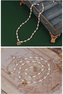 Detail of freshwater pearl necklace with gold heart pendant on vintage background