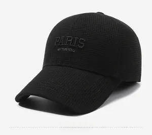 Detail of black baseball cap showing breathable mesh texture and Paris embroidery