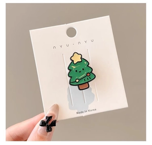 Détail de la broche sapin de Noël vert avec étoile sur carte d'emballage de marque