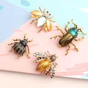 Detail of four insect brooches with rhinestones and gems on an artistic board