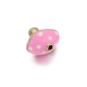 Macro detail of a pink mushroom enamel bead with white dots for DIY jewelry making