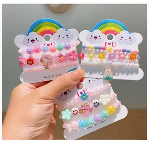 Close-up of three colorful acrylic beaded bracelets with rainbow and bear charms for girls
