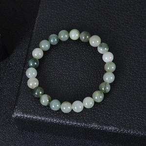 Detailed close-up of natural green jade beaded bracelet on black textured background