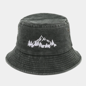 Gros plan sur la broderie de montagne d'un chapeau bob en coton délavé avec œillets
